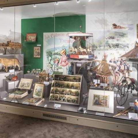 Une vitrine présentant divers anciens jouets