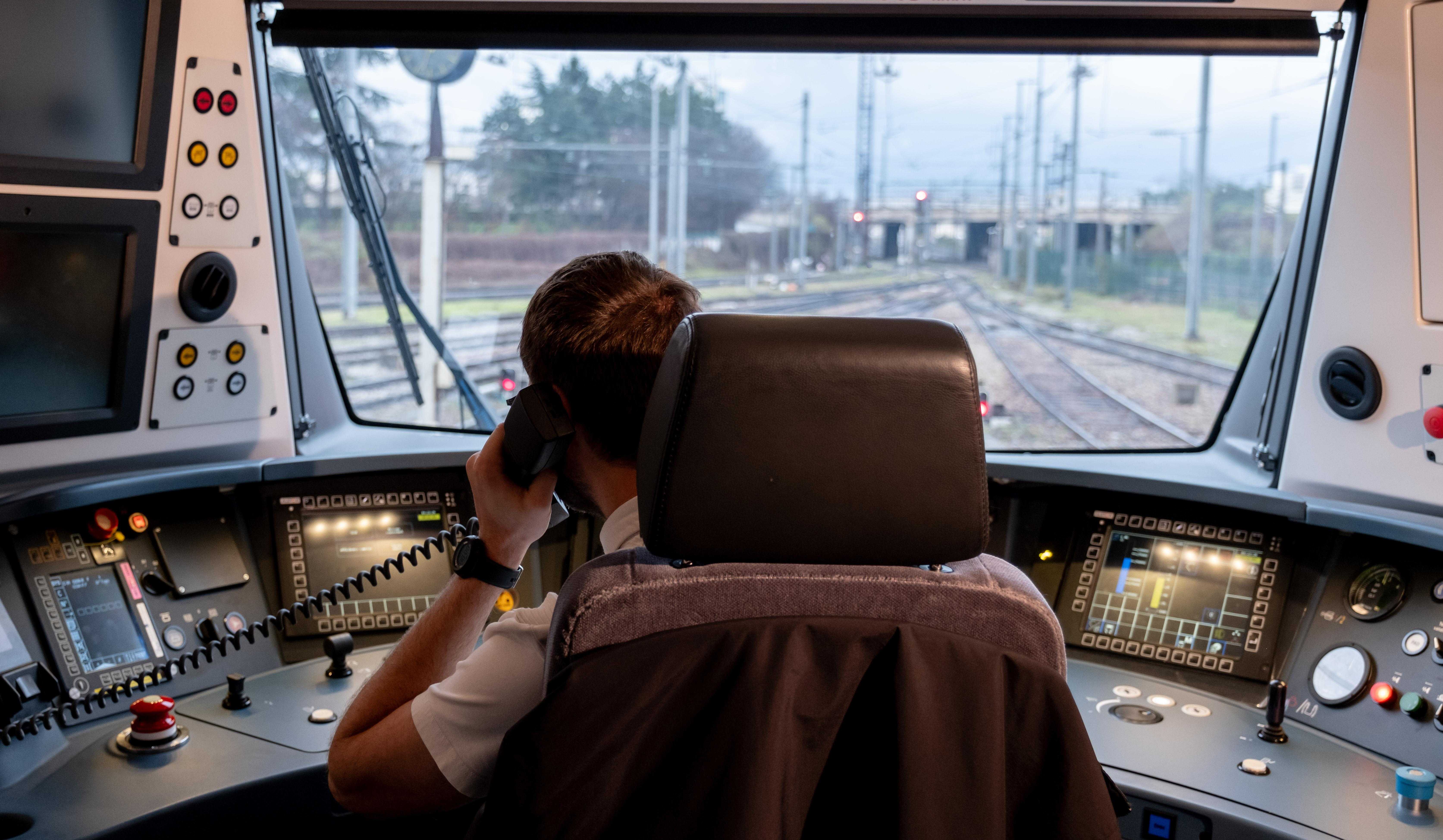 Photo d'un conducteur (de dos) assis dans sa cabine de conduite