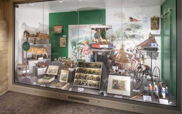Une vitrine présentant divers anciens jouets