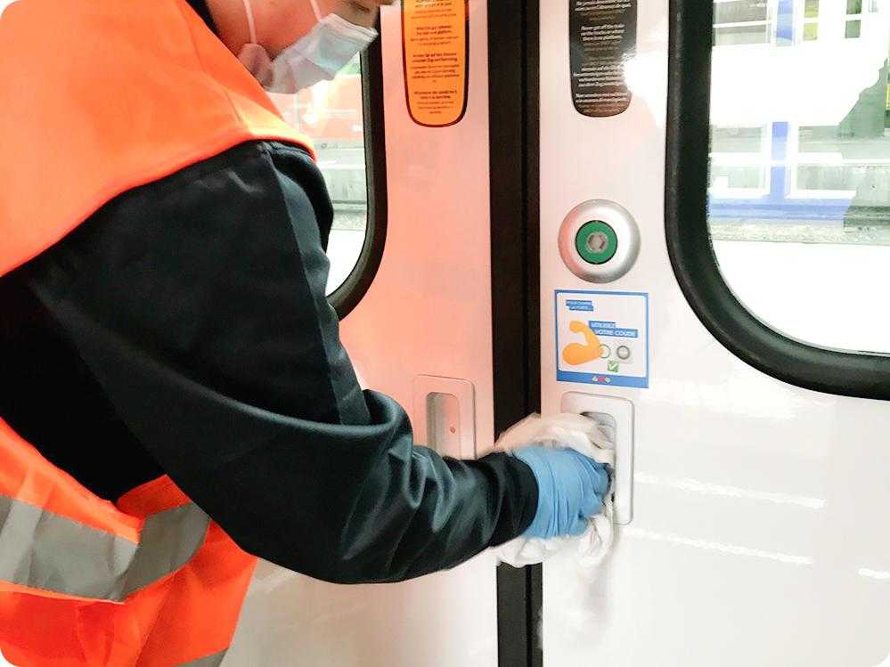 Un agent nettoie la porte d'un train