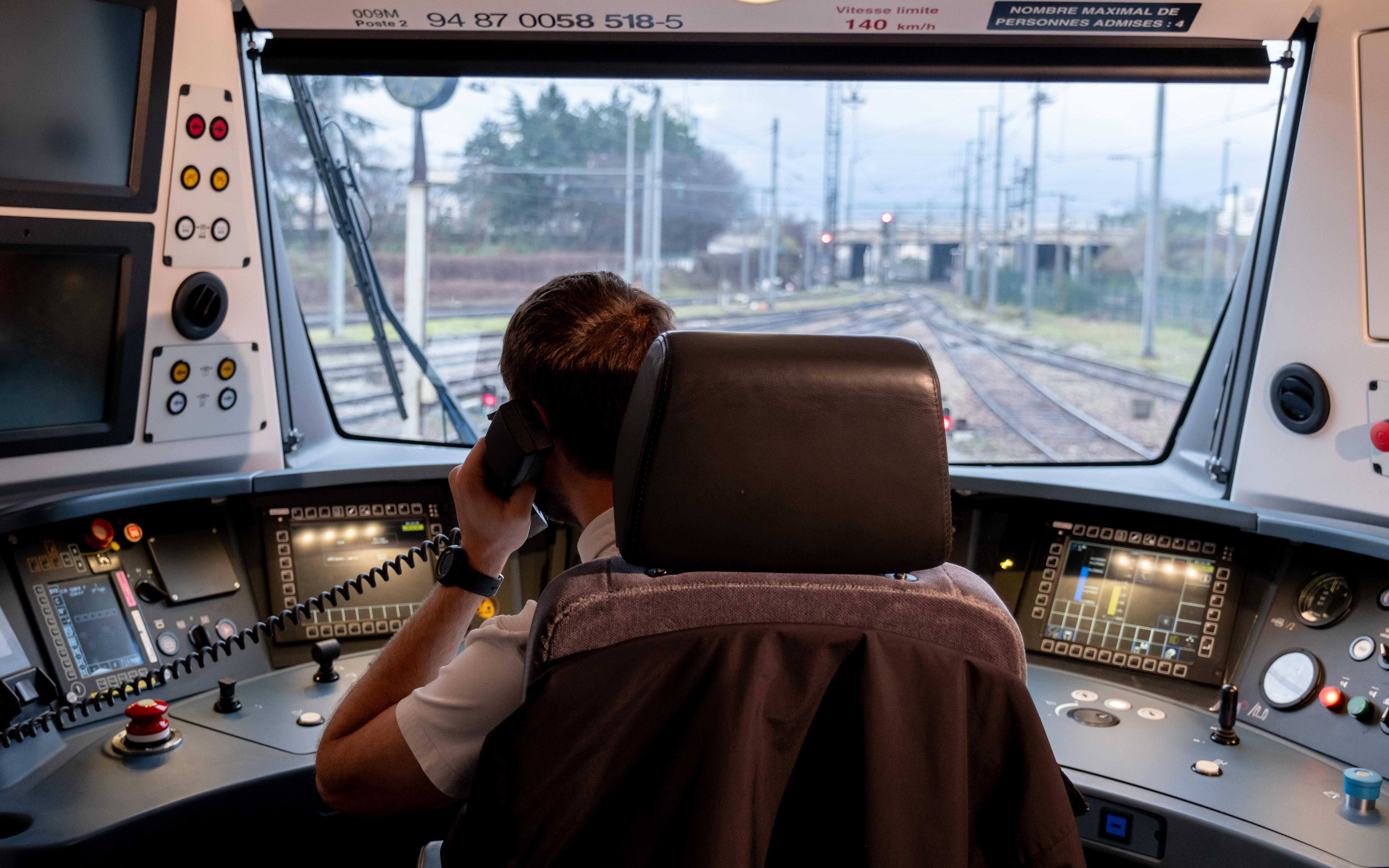Photo d'un conducteur (de dos) assis dans sa cabine de conduite