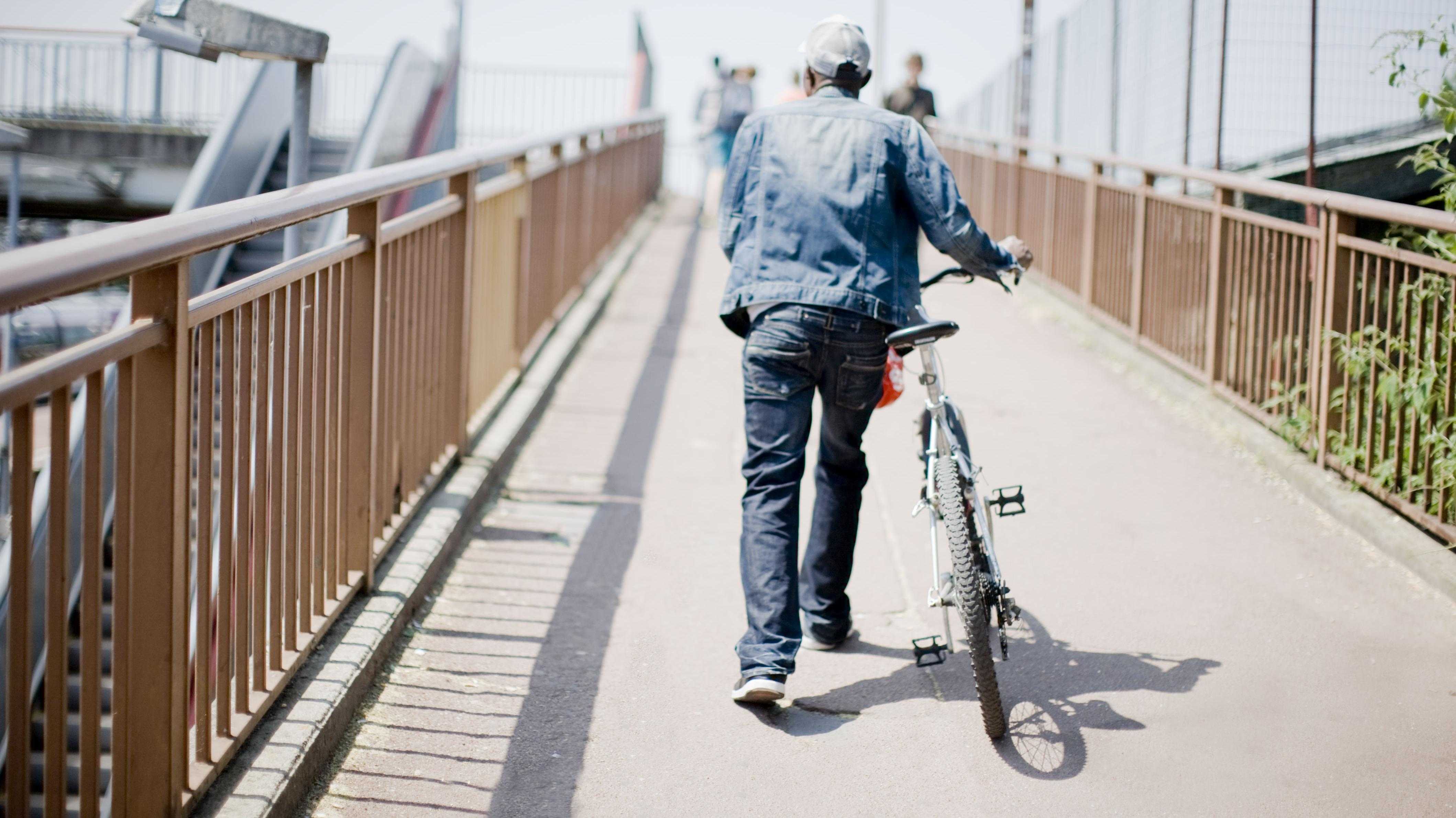 Un homme marche à côté de son vélo