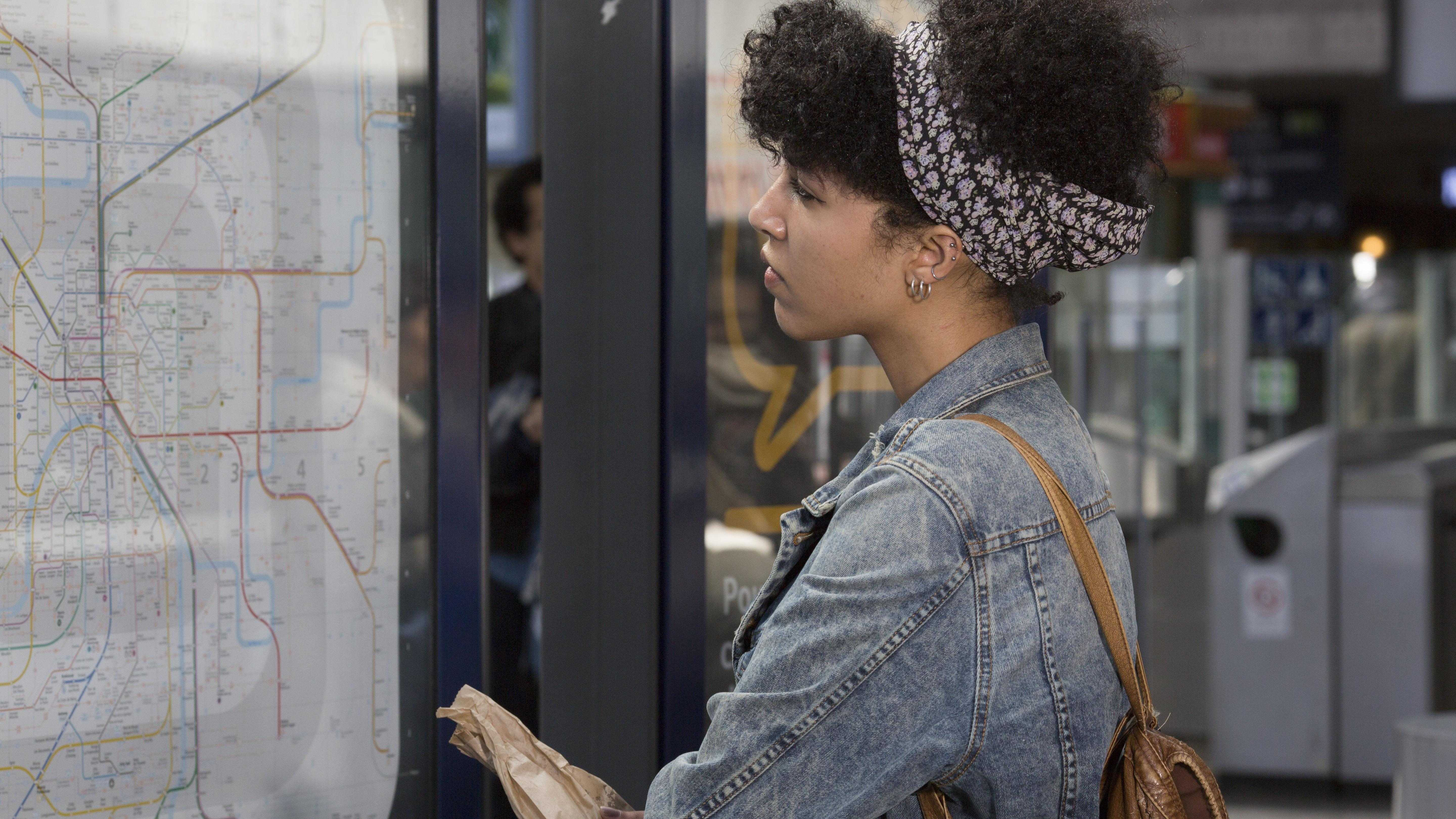 Jeune femme regarde un plan Transilien