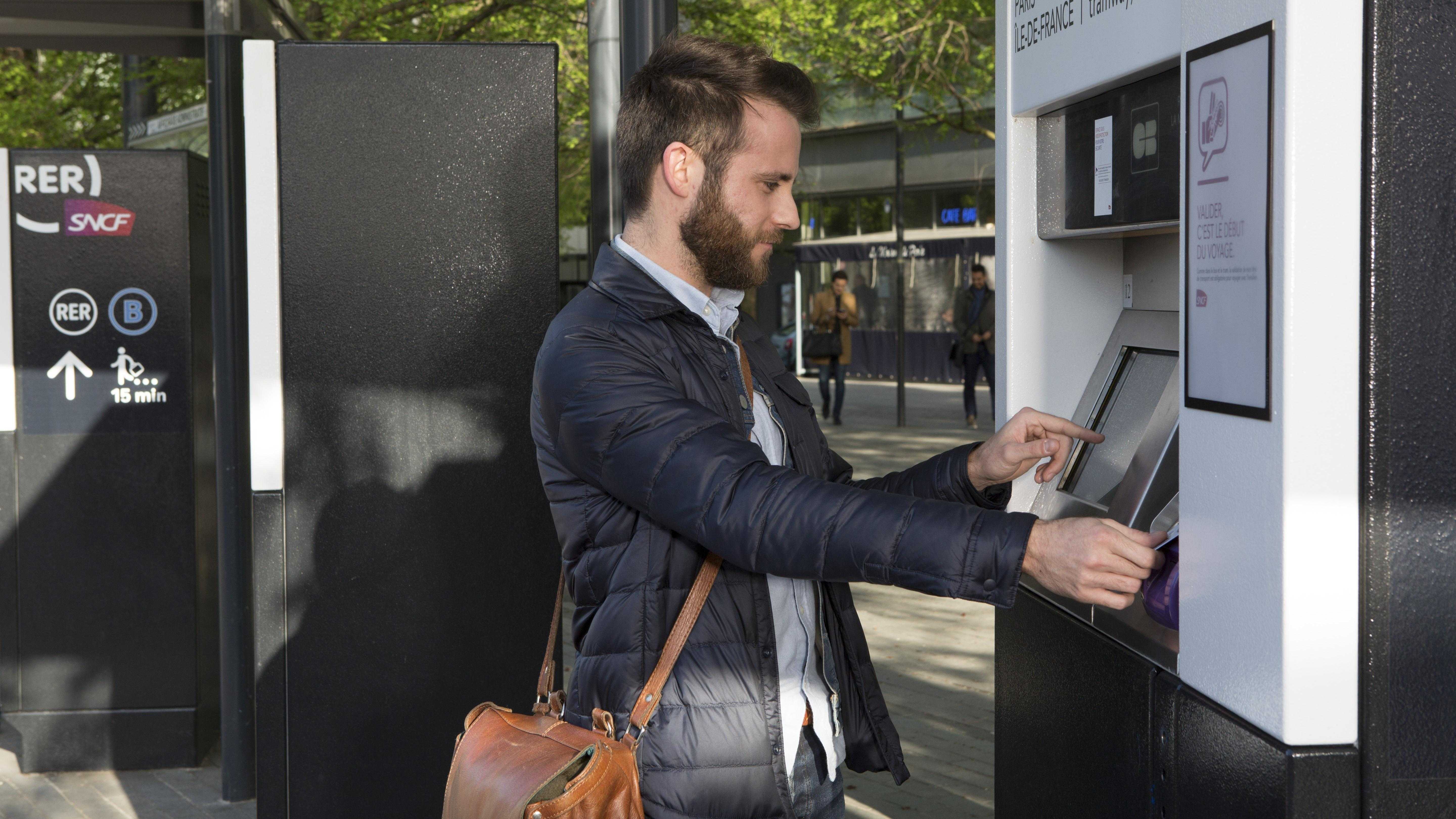 Voyageur achète son ticket sur automate de vente Transilien
