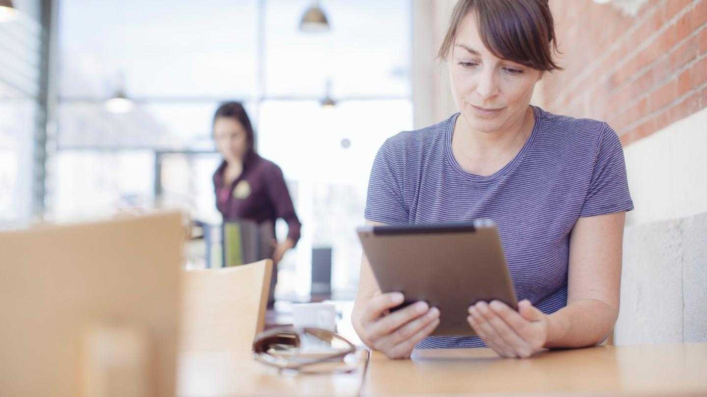 Femme lit un livre sur sa tablette