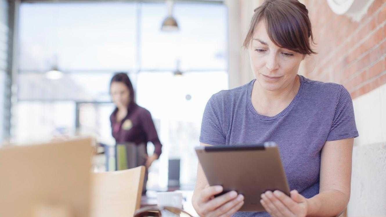 Femme lit un livre sur sa tablette