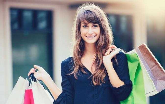 Une jeune femme tenant plusieurs sacs de course